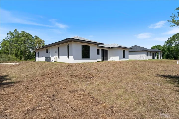 View of front of home featuring stucco siding and a front yard