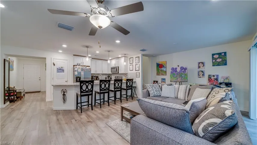 Living area with ceiling fan, light wood-type flooring, and recessed lighting
