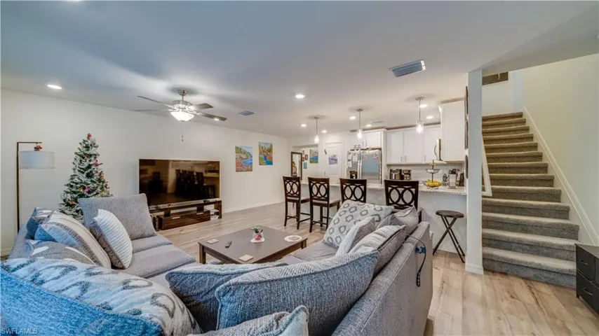 Living area with stairway, recessed lighting, light wood-style floors, and a ceiling fan