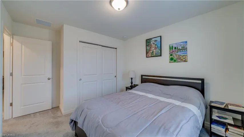 Bedroom featuring light colored carpet and a closet