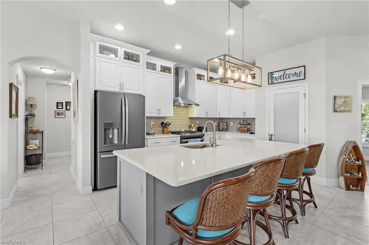 The kitchen has a tile backsplash and glass doors on the top wall cabinets.