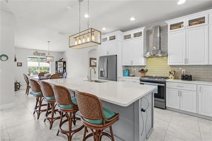 The kitchen with breakfast bar, quartz counters, and stainless appliances.