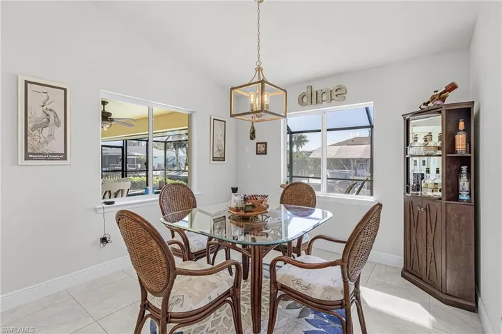 The dining area overlooks the pool, lanai, and canal.
