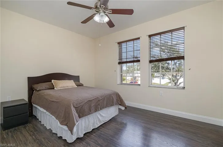 Bedroom with dark hardwood / wood-style floors and ceiling fan