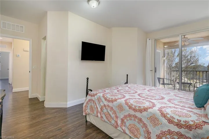 Bedroom with access to exterior and dark hardwood / wood-style flooring