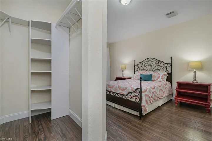 Bedroom with dark hardwood / wood-style flooring