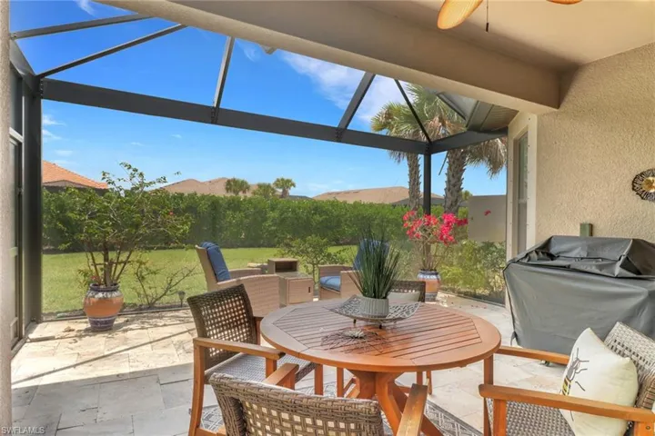 View of patio with outdoor dining space, ceiling fan, lanai and grilling area