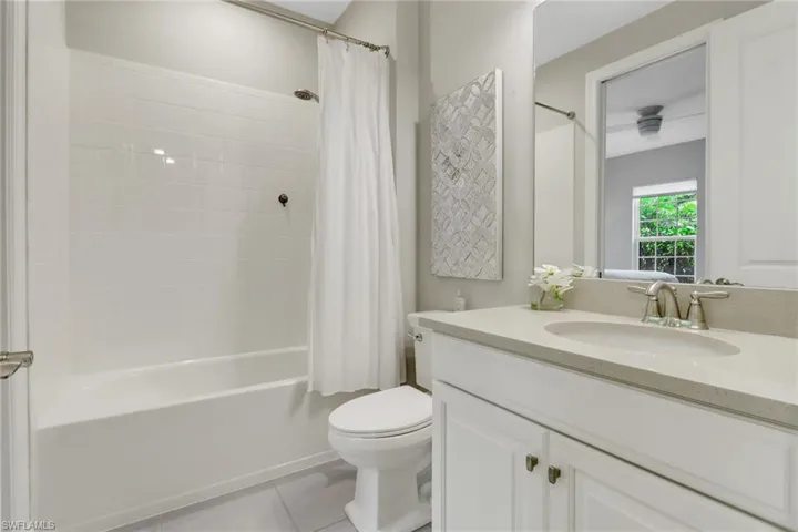 Full bathroom featuring tile patterned flooring, vanity, and shower / bathtub combination with curtain