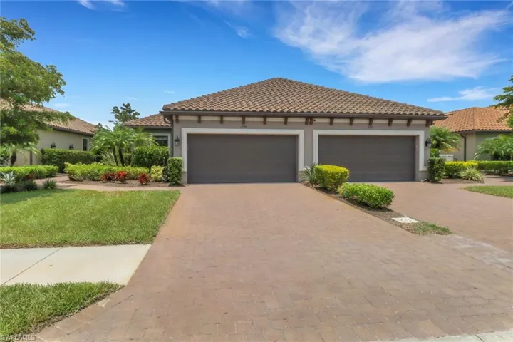 Mediterranean style Mazzano villa featuring decorative paver driveway, stucco siding, an attached garage, and a tiled roof