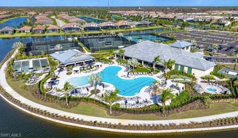 Aerial perspective of suburban area featuring a pool and a large body of water