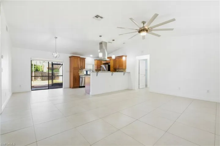 Unfurnished living room featuring vaulted ceiling, recessed lighting, light tile patterned floors, and a ceiling fan