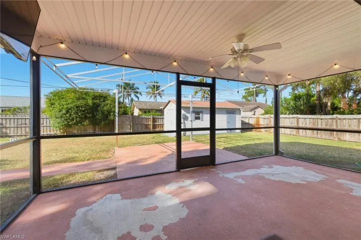 Unfurnished sunroom with a ceiling fan and a patio
