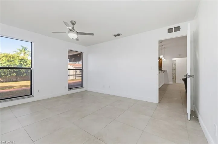 Unfurnished room featuring light tile patterned flooring and a ceiling fan