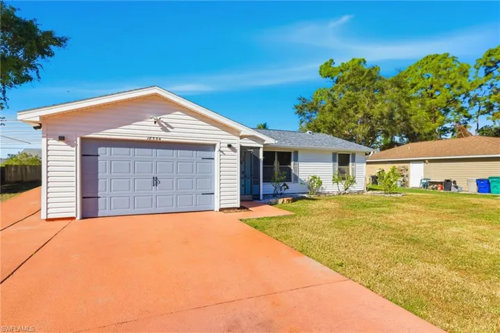 Ranch-style home with a front yard, driveway, and a garage