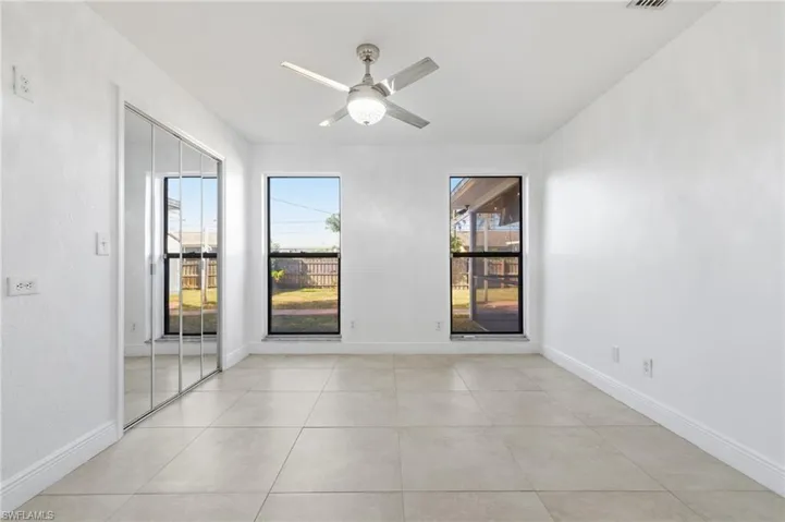Unfurnished room with ceiling fan and light tile patterned floors