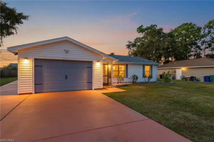 Ranch-style home with a yard, concrete driveway, and an attached garage