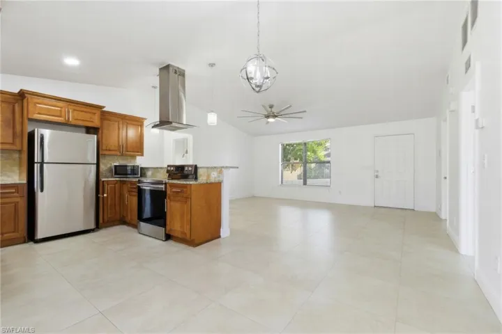 Kitchen featuring wood finish cabinets, stainless steel appliances, island exhaust hood, a peninsula, and ceiling fan