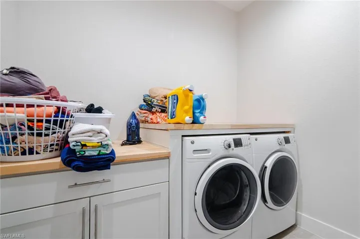 Laundry room featuring cabinets and washer and dryer