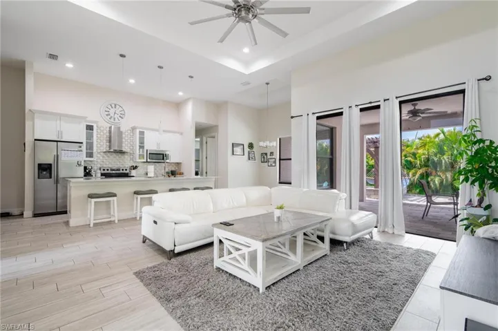 Living room with ceiling fan and a tray ceiling