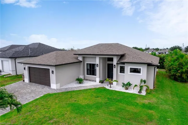 2019 built house featuring a garage and a front lawn