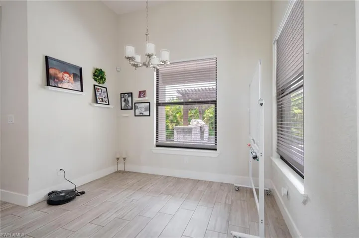 Unfurnished room with a notable chandelier and light hardwood / wood-style flooring