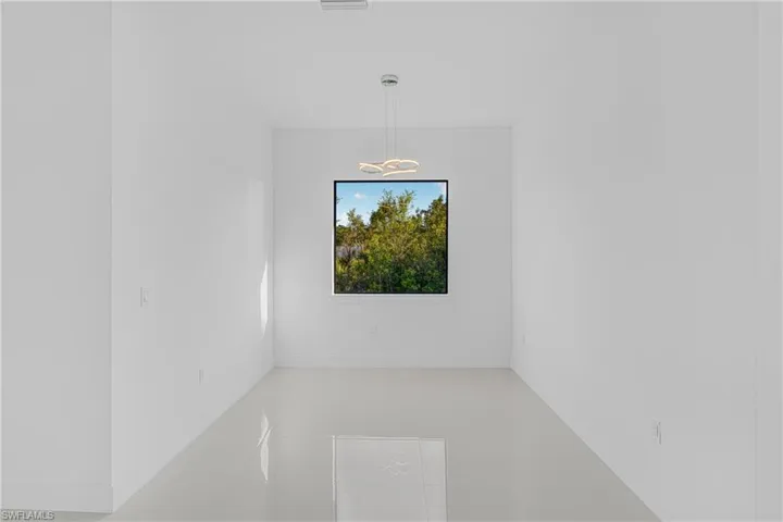 Tiled spare room featuring baseboards