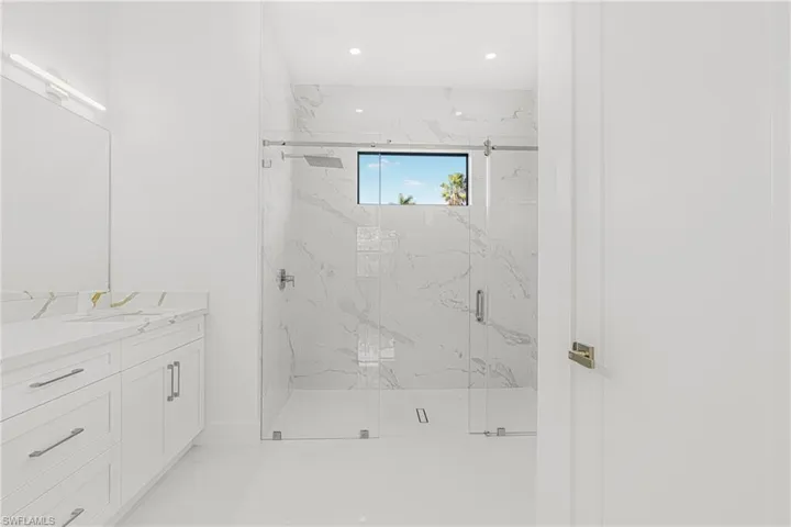 Full bathroom featuring recessed lighting, a marble finish shower, and vanity