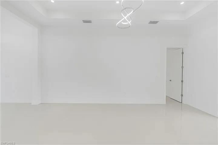 Empty room featuring recessed lighting, visible vents, and baseboards
