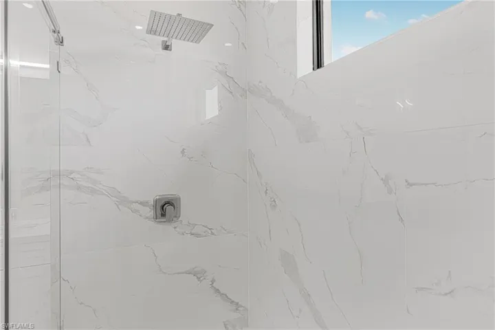 Room details featuring a marble finish shower