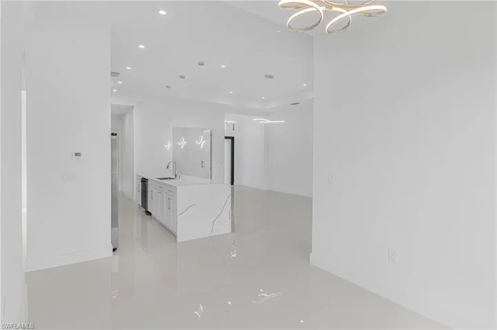 Unfurnished room with recessed lighting, baseboards, and a sink