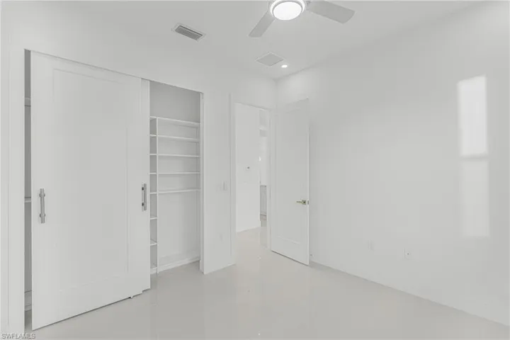 Unfurnished bedroom with a ceiling fan, visible vents, a closet, and baseboards