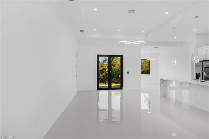 Spare room with a raised ceiling, recessed lighting, visible vents, and french doors