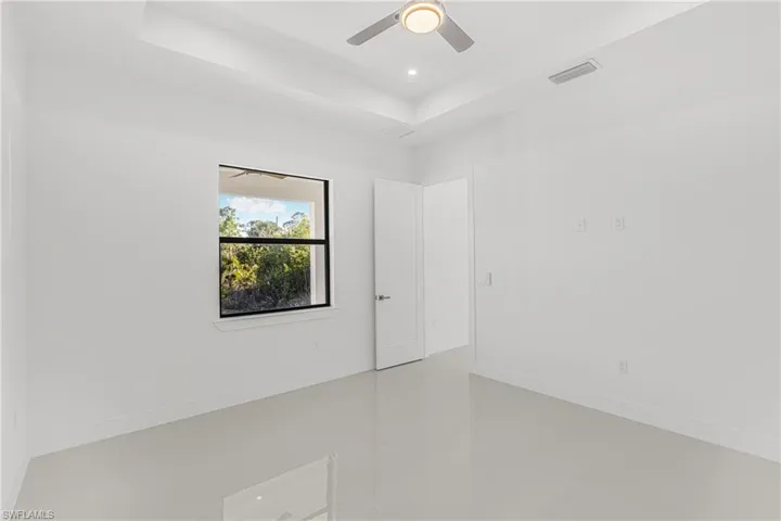 Spare room with visible vents, recessed lighting, baseboards, and a tray ceiling