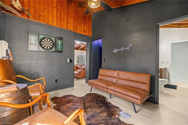 Living area featuring ceiling fan, a textured wall, and light wood finished floors
