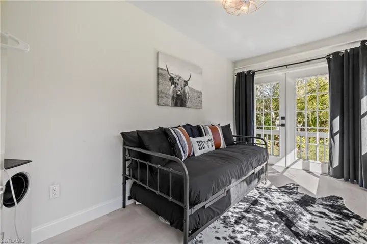 Bedroom featuring french doors, access to outside, washer / dryer, and light wood-type flooring