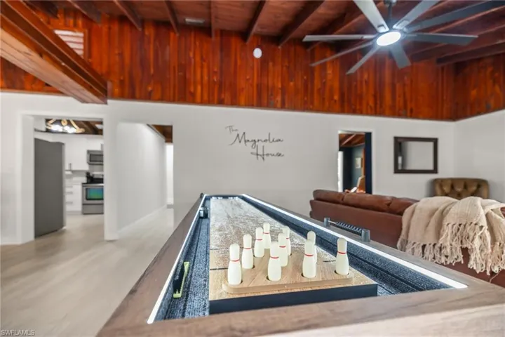 Rec room featuring a wood ceiling with exposed beams, a ceiling fan, and wood finished floors