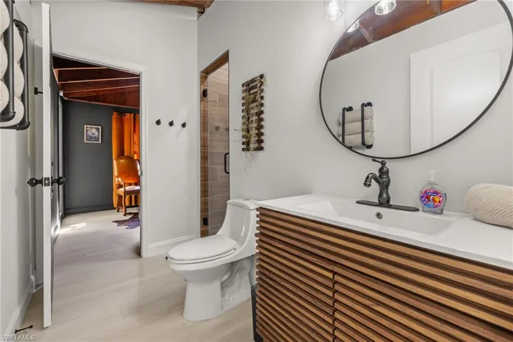 Full bath featuring a stall shower, vanity, and light wood finished floors