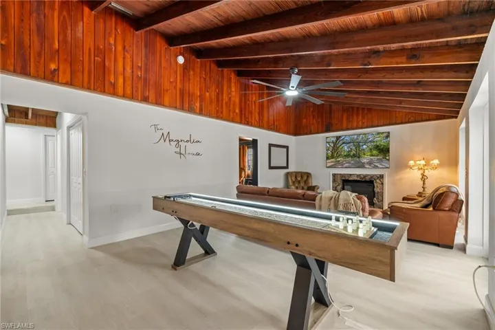 Rec room featuring a fireplace, wooden ceiling, ceiling fan, and light wood finished floors