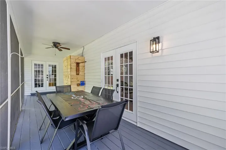 Deck with french doors, outdoor dining area, and ceiling fan