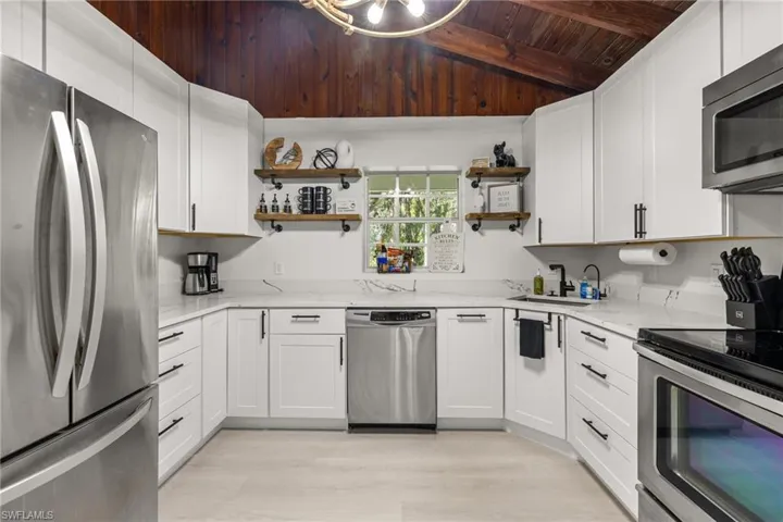 Kitchen featuring open shelves, appliances with stainless steel finishes, light stone counters, wood ceiling, and white cabinets
