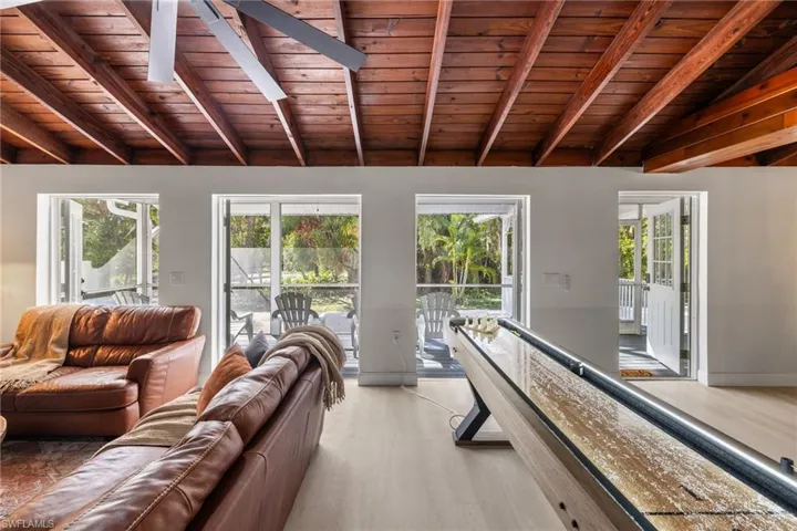 Living room with wooden ceiling, healthy amount of natural light, and light wood-style floors