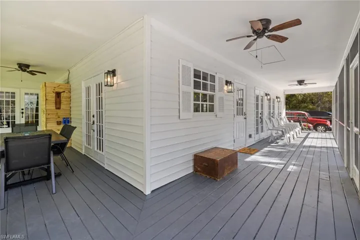 Porch with ceiling fan, french doors, and outdoor dining space