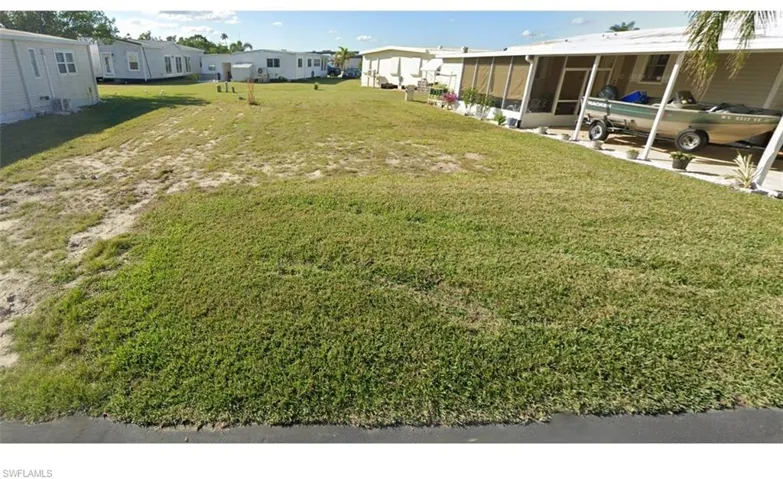 View of green lawn featuring a sunroom and a residential view