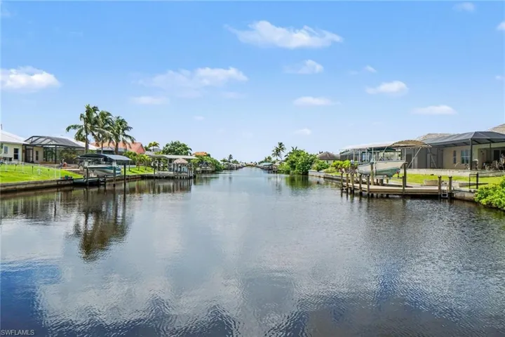Waterfront property featuring canal access, private docks, screened enclosures, and mature palm trees