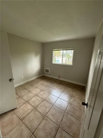 Spare room featuring a textured ceiling and light tile patterned floors