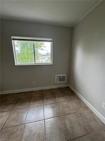 Empty room with light tile patterned flooring and a textured ceiling
