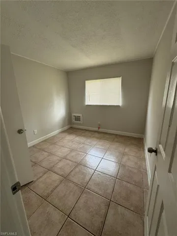 Unfurnished room featuring a textured ceiling and light tile patterned floors