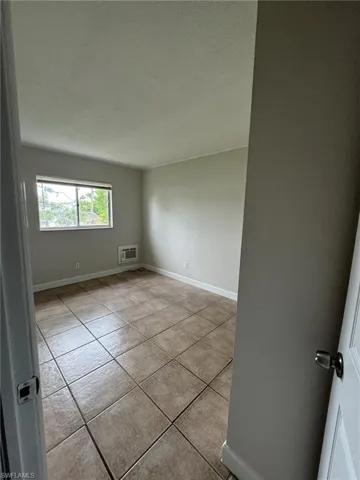 Unfurnished room with a textured ceiling and light tile patterned floors