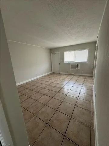 Unfurnished room featuring tile patterned flooring and a textured ceiling