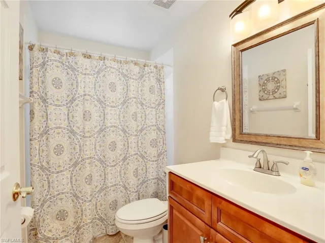 Bathroom with vanity, toilet, and a shower with curtain
